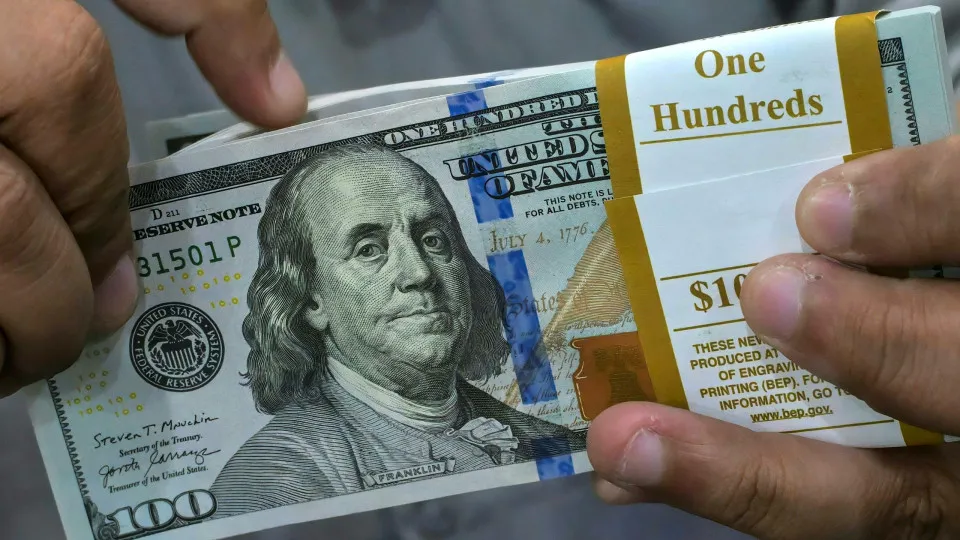 Dólar cai e Bolsa recua pressionada por balanços do varejo